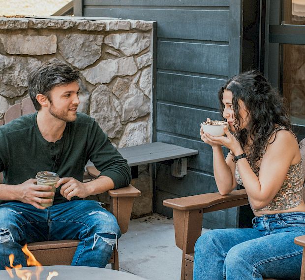 A couple having coffee by the firepit at The Ozarker Lodge.