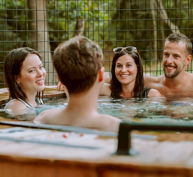 Couples soaking in the creekside hot tubs.