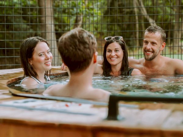 A couple in the creekside hot tub at The Ozarker.