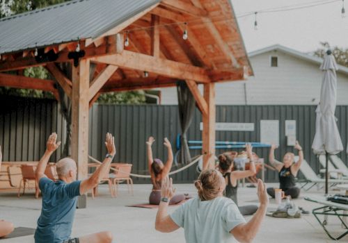 A group of people practicing yoga poolside at The Ozarker.