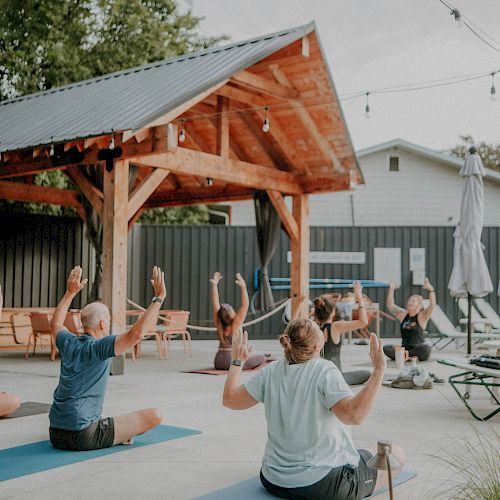 A group of people practicing yoga poolside at The Ozarker.