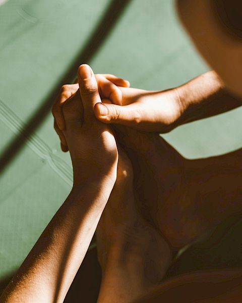 A person practicing yoga on a green yoga mat.