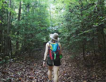A woman hiking in a forest.
