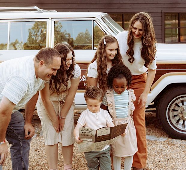 A family looking at a map next to a Wagoneer.
